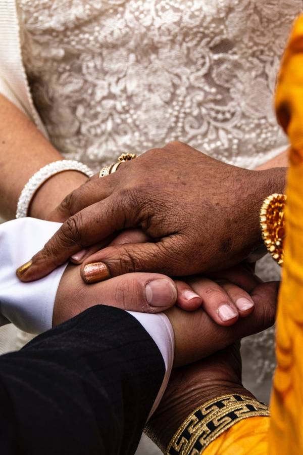 A couple holding hands while making their wedding vows