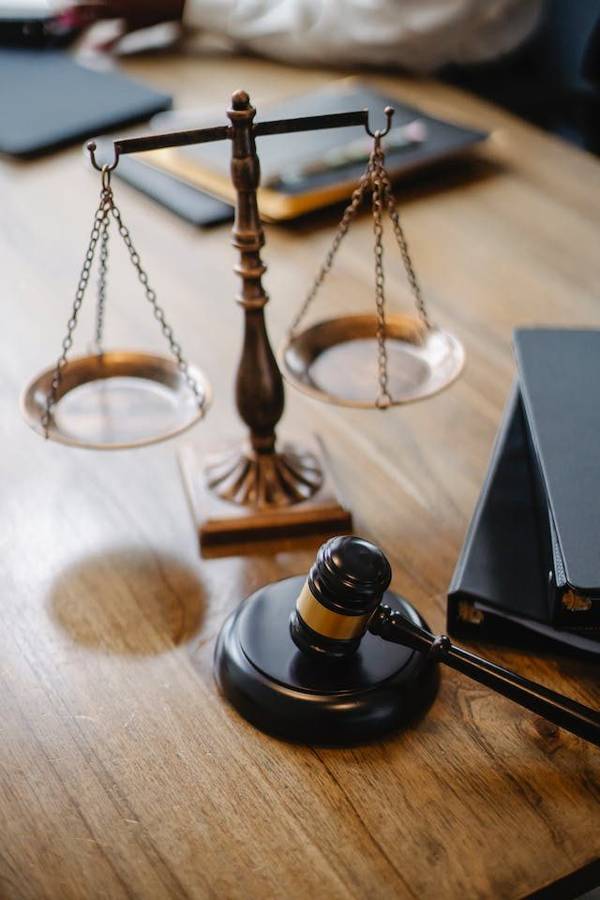 A brass set of scales and a judge's gavel on a desk, a reminder that marriage laws differ by place
