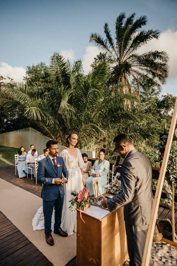An officiant reading from a wooden lectern with a microphone while the couple stands before him