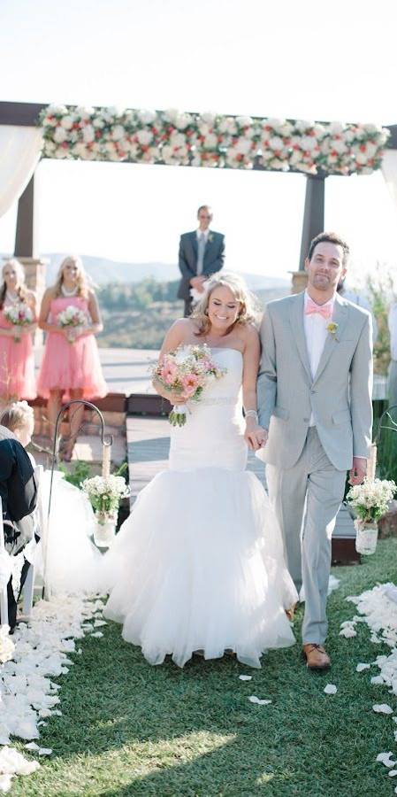 A newly married couple walking hand in hand back up the aisle