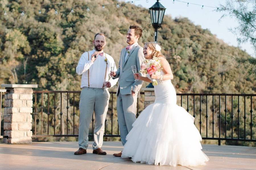A best man giving a toast as the bride and groom laugh