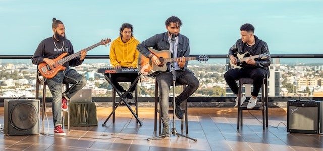 A four-piece band playing on a sunny rooftop